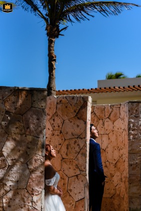   Unique patterns of light and impressive architecture blend with palm trees in Playa del Carmen, Mexico, emphasizing the tropical elegance of the destination wedding portrait for the couple.